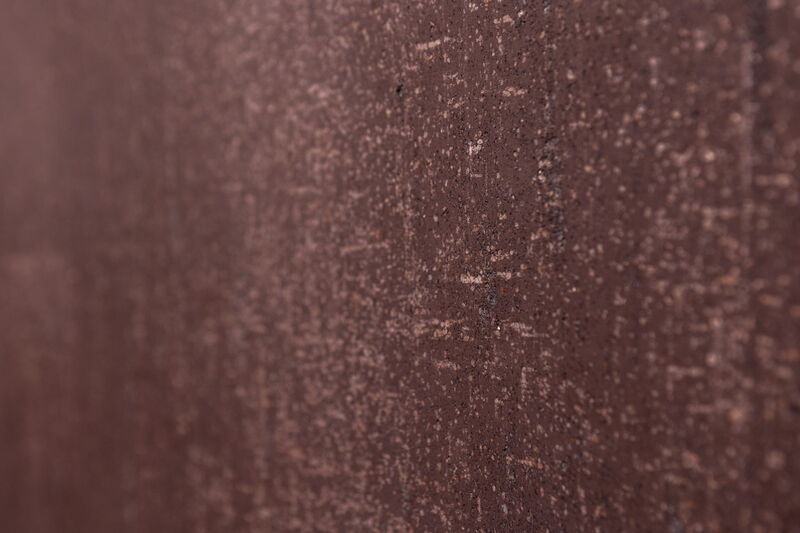 Close-up of a dark natural lime plaster surface with fine texture