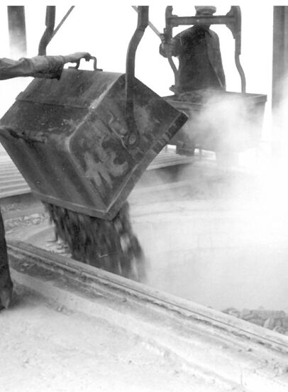 Historic photo of lime production with workers emptying a container