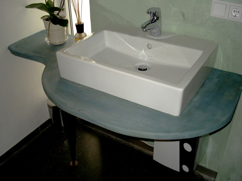 Washbasin on a modern countertop with natural lime plaster wall finish in the bathroom