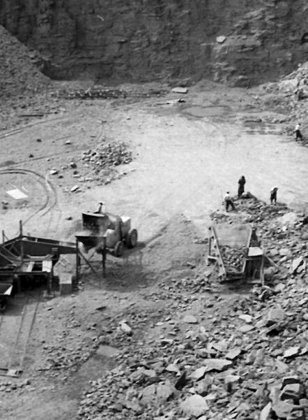 Historic photo of a limestone quarry with excavation work and conveyor equipment