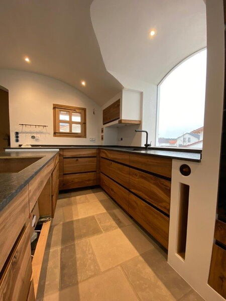 Moderne Küche mit Holzfronten und weißem Naturkalkputz an Wänden und Decke