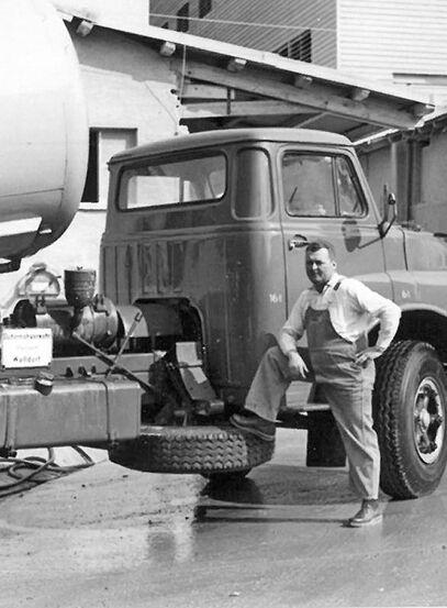 Historic photo of an employee in front of a Hessler lime truck on the plant site